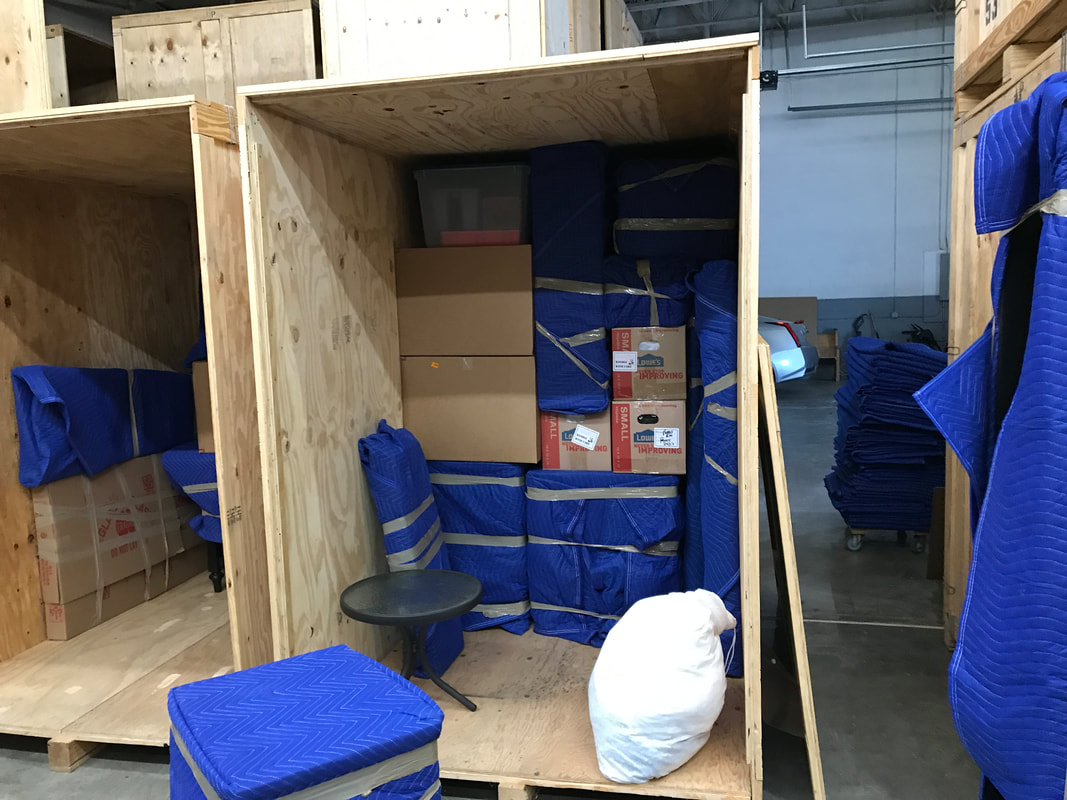 An image of wooden boxes stacked neatly in a warehouse, with parcels inside or nearby